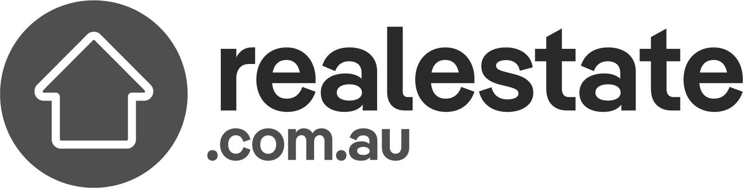 Logo of realestate.com.au, featuring a white outline of a house within a dark circular background on the left. To the right of the circle, the text "realestate.com.au" is depicted in bold, sans-serif font, embodying simplicity and modernity for those seeking the best duplex designs by renowned Sydney architects.